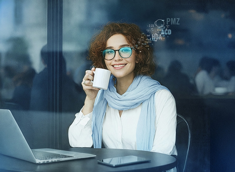 Ženska, ki sedi za prenosnim računalnikom in išče optika Rodenstock v bližini 